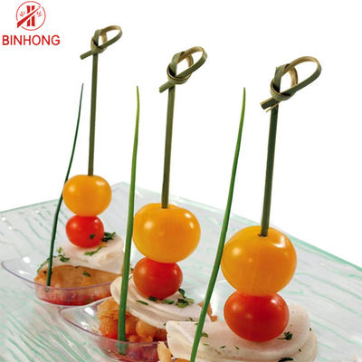 Palillos colocados de bambú disponibles del pincho de la fruta